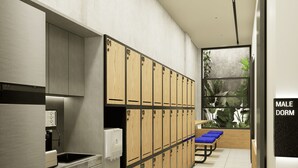 A modern male dormitory with lockers, a kitchenette, and a bench with blue cushions. - Volbs (Tabanan)