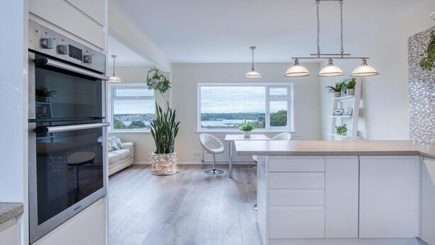Una cucina moderna con forno integrato, una zona pranzo con vista e un'ampia finestra.