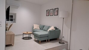 A modern living room with a grey sofa, a small round table, and a floor lamp.