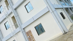 A multi-story building with a modern architectural design, featuring a series of rectangular windows and balconies. - Ox Apartment (Suva)