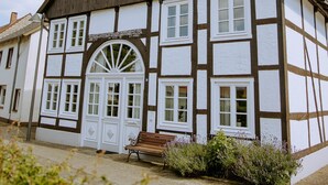 A traditional half-timbered building with a large arched doorway and multiple windows. - Studio 28 (Rietberg)