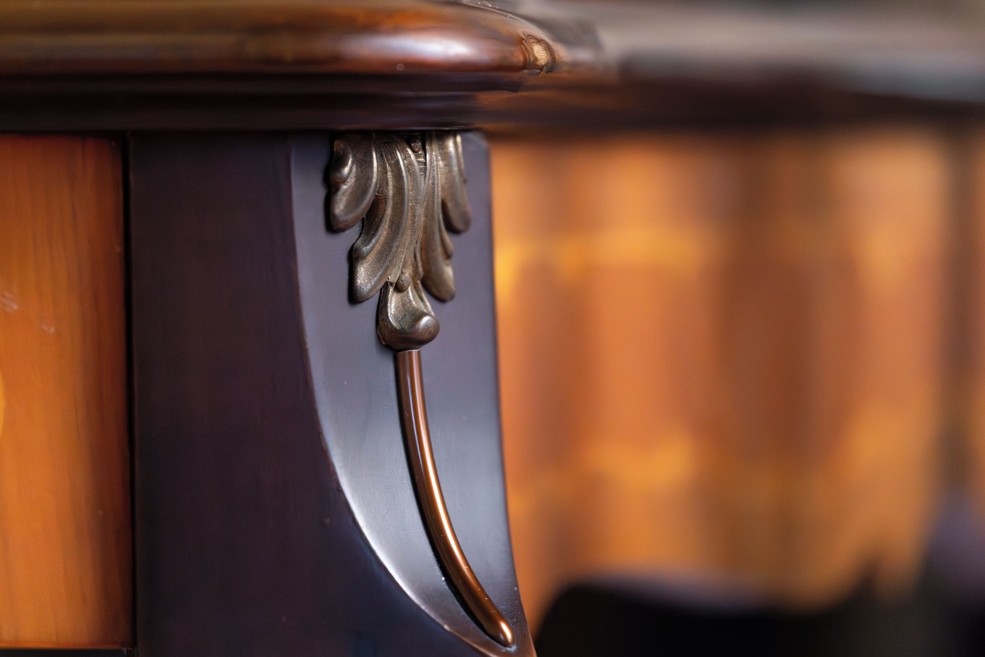 A close-up of a wooden and metal furniture piece with a curved design.