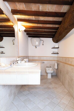 A bathroom with two sinks, a bidet, and a mirror. - Raffaello  (Perugia)