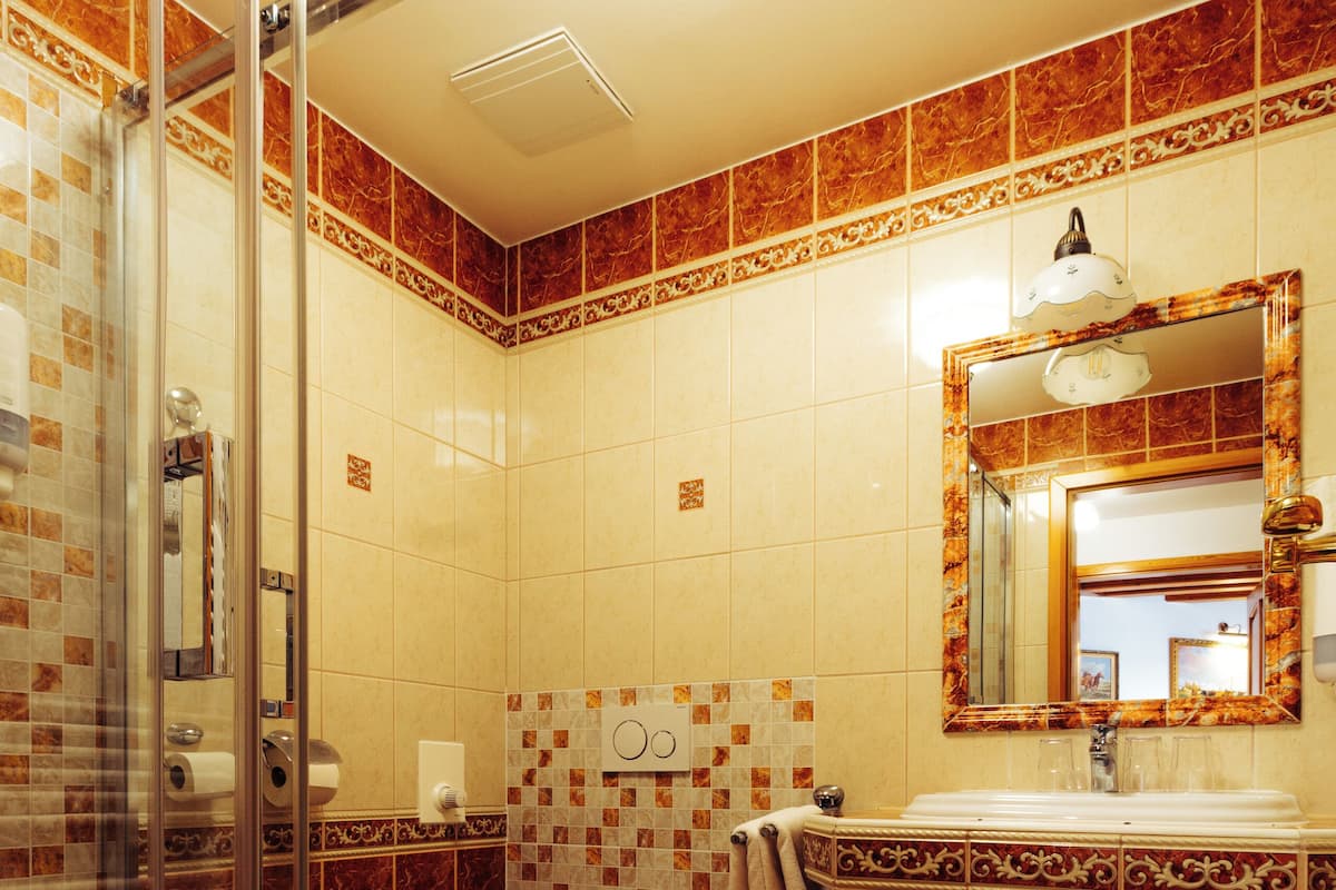 Un baño con cabina de ducha de vidrio, un inodoro y un lavabo con espejo.