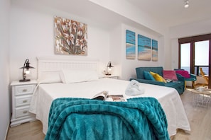 Relax in this stylish room with a large bed, sofa, and ocean views through large windows.