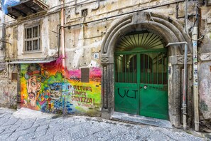 Ένα κτίριο με μια πράσινη πόρτα και μια πολύχρωμη τοιχογραφία στον τοίχο.