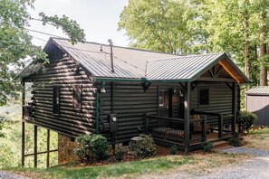 A log cabin with a porch and a small attached structure. - Views @ Whitepath | Mtn Views + Hot Tub + Fire Pit (Ellijay)