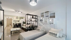 A modern, well-lit bedroom with two beds, a dining area, and a kitchen. - Modern Studio In San Telmo With Pool - Paseo 423 (Buenos Aires)