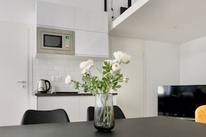 Apartamento família, vista para o pátio | Cozinha americana privada | Geladeira, micro-ondas, cooktop, talheres/pratos/utensílios de cozinha