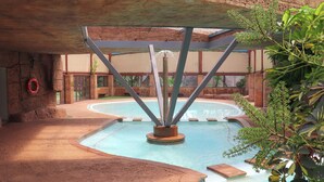 A pool area with a central water feature, surrounded by stone walls and potted plants. - Olifants River Camping by Dream Resorts (Middelburg)