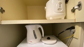 A microwave and a kettle on a shelf, with a power cord plugged in. - W311 Tokyo Monthly rental- Sakurashinmachi Sunrise (Setagaya City)