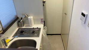 Une petite cuisine équipée avec une cuisinière à gaz, un évier et un petit plan de travail.