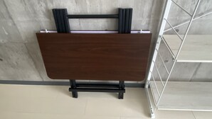 Ein Holzkabinent mit Metallrahmen, an einer Betonwand in einem Raum mit Fliesenboden.
