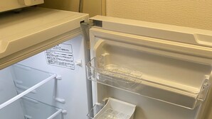 Un réfrigérateur ouvert, doté de plusieurs étagères et d’un distributeur d’eau.