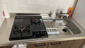 Une cuisine équipée d’une cuisinière, d’un évier et d’un rouleau d’essuie-tout.