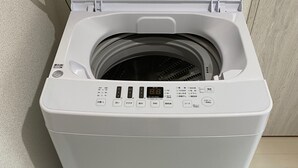 Vue de face d’un lave-linge à chargement frontal blanc, doté d ’un écran numérique, d’un panneau de commande et d’une porte transparente.