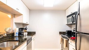 Une cuisine compacte équipée d’un four à micro-ondes, d’une cuisinière et d’un réfrigérateur.