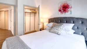 Ein Schlafzimmer mit einem großen Bett, einem Kleiderschrank und einem Bild an der Wand.