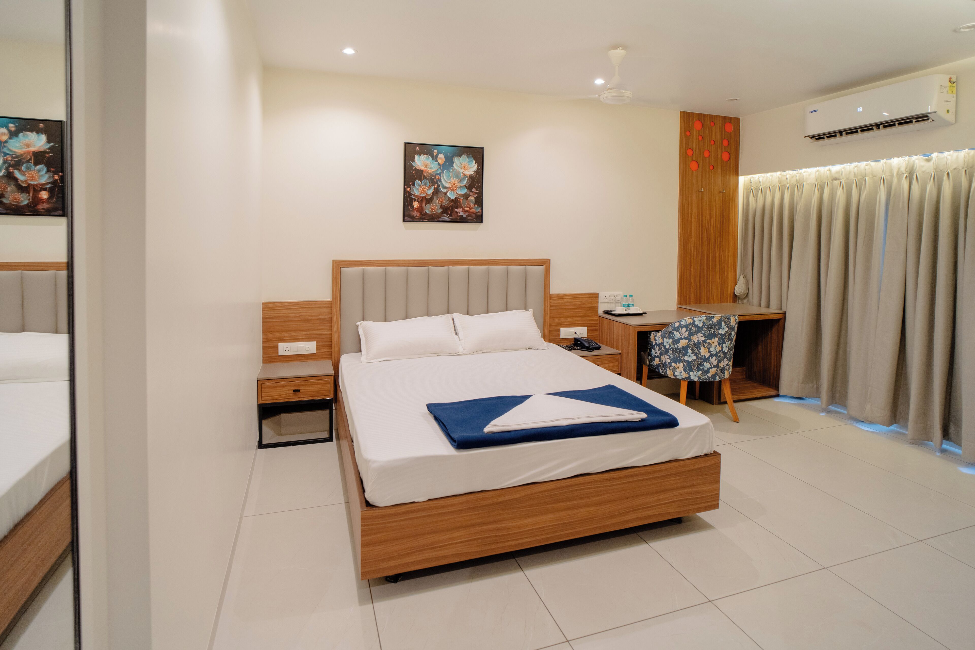 Une chambre d’hôtel moderne avec un grand lit, un bureau et une chaise.