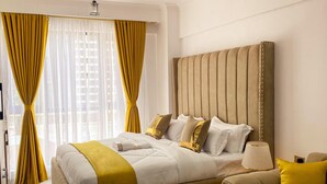 A modern bedroom with a large bed, a headboard with vertical lines, and a bedside table with a lamp. - Smart Homes - The Luxe Retreat (Nairobi)