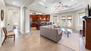 A spacious living room with a sofa, coffee table, and a view of the kitchen.