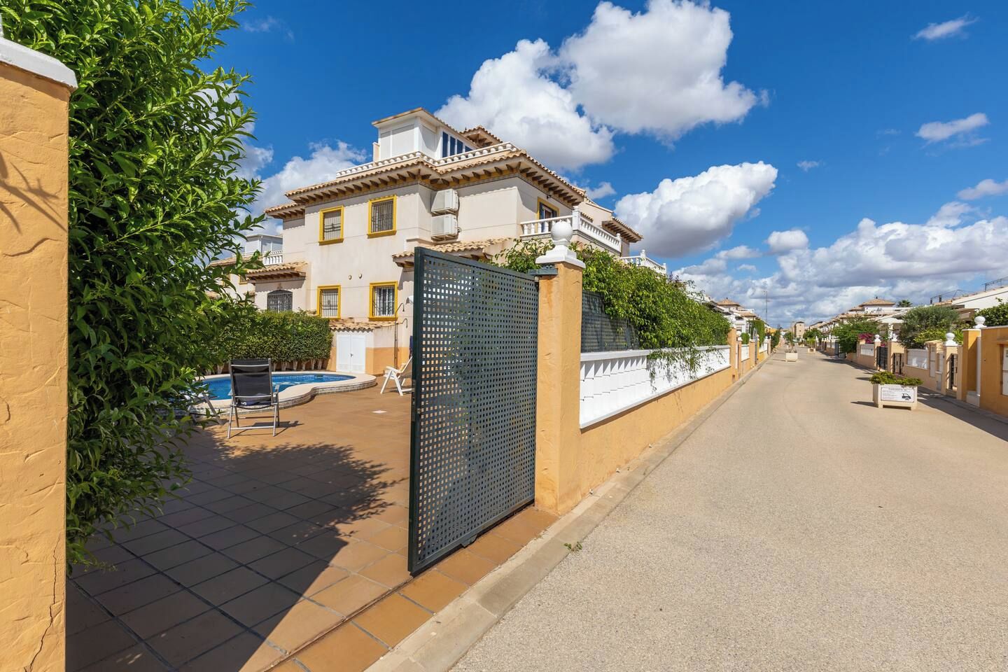 Une propriété résidentielle dotée d’une piscine, d’une entrée sécurisée et donnant sur la rue.