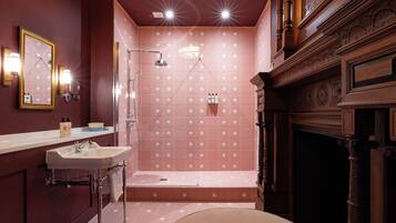A bathroom with a sink, mirror, and shower.