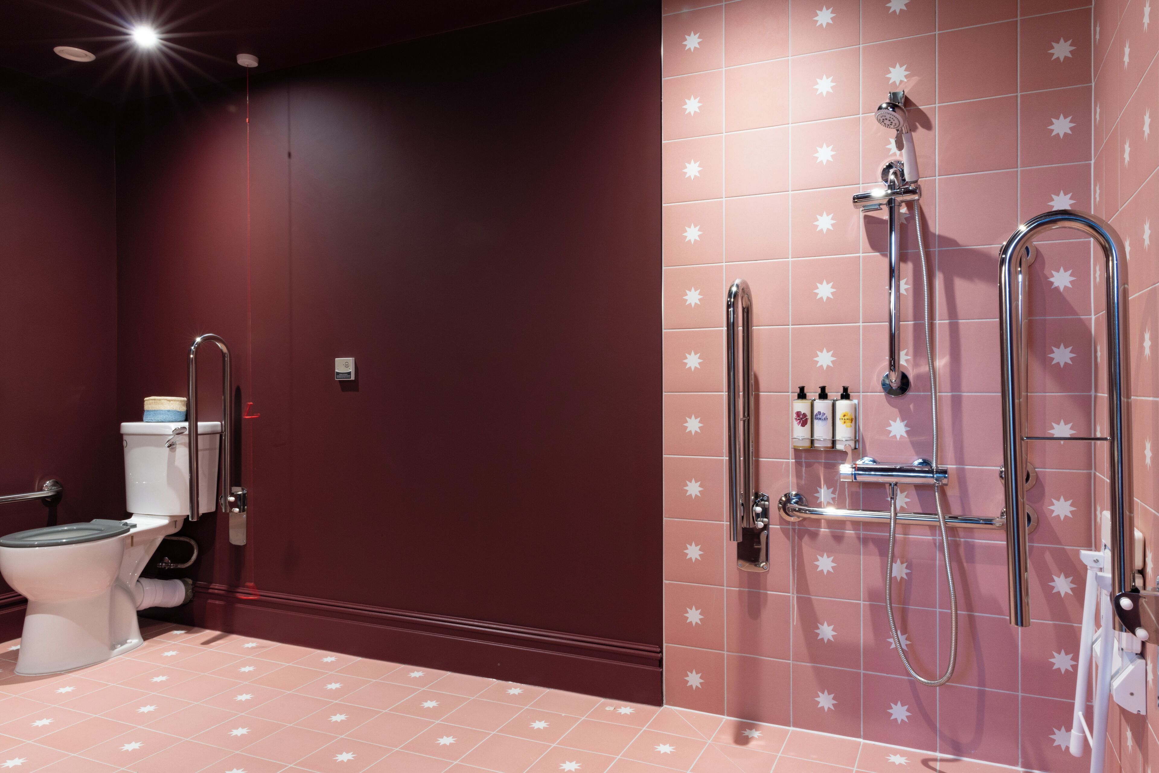 A bathroom with a toilet, a shower, and a sink.