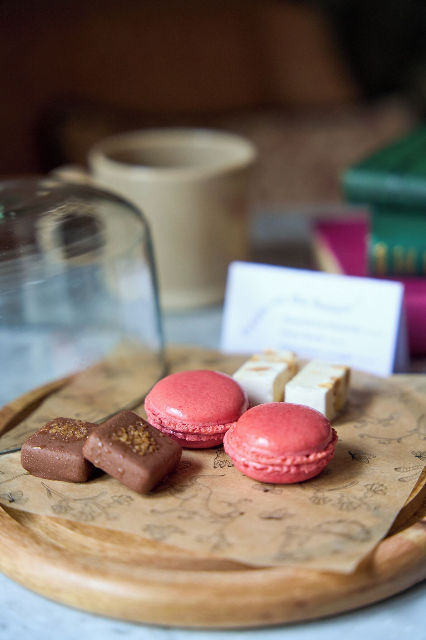 A tray with macarons and chocolates on parchment paper.