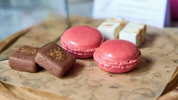 A tray with macarons and chocolates on parchment paper.