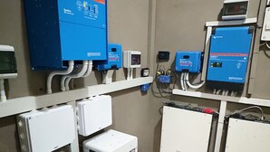 Uma sala de serviços com quadros elétricos, caixas de controle e unidades de refrigeração.