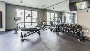 A gym with cardio machines, weight benches, and a rack of dumbbells. - West End Getaway for 5 w/Pool! (Nashville)