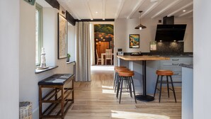 Une cuisine moderne dotée d’un îlot central, de tabourets de bar et d’un coin repas avec des chaises.