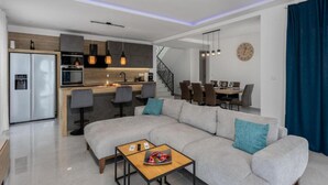 Un appartement moderne comprenant un salon, une cuisine, un coin repas et un escalier.