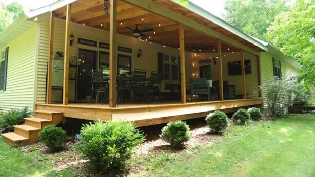 Une maison de plain-pied dotée d’un porche abrité, d’un coin repas et d’un petit jardin.