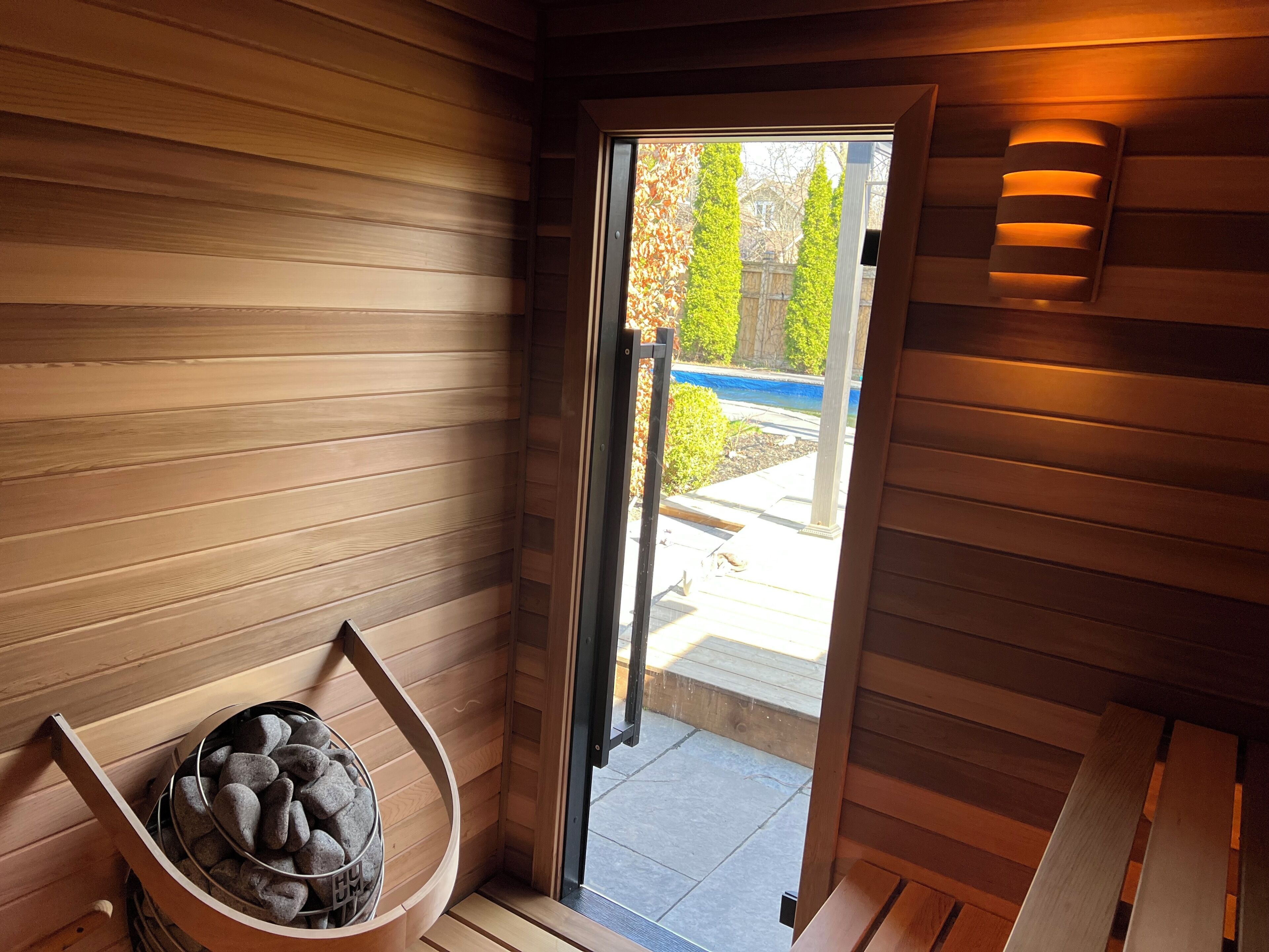 Cedar sauna with view of pool