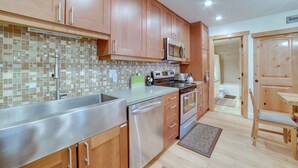A kitchen with wooden cabinets, stainless steel appliances, and a tiled backsplash. - Ski Condo w/ Community Amenities in Mammoth Lakes! (Mammoth Lakes)