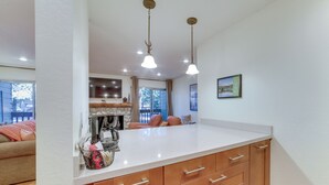 A kitchen with wooden cabinets, a white countertop, and pendant lighting. - Ski Condo w/ Community Amenities in Mammoth Lakes! (Mammoth Lakes)