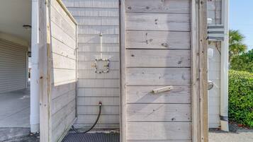 A wooden shed with a door, a small window, and a hose connected to the exterior wall.