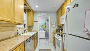 A kitchen with wooden cabinets, a white refrigerator, and a microwave. - Walk to Citrus Hills Golf Club: Condo w/ Pool! (Hernando)