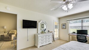 A bedroom with a bed, a dresser, a TV, a desk with a computer, and a ceiling fan. - Walk to Citrus Hills Golf Club: Condo w/ Pool! (Hernando)