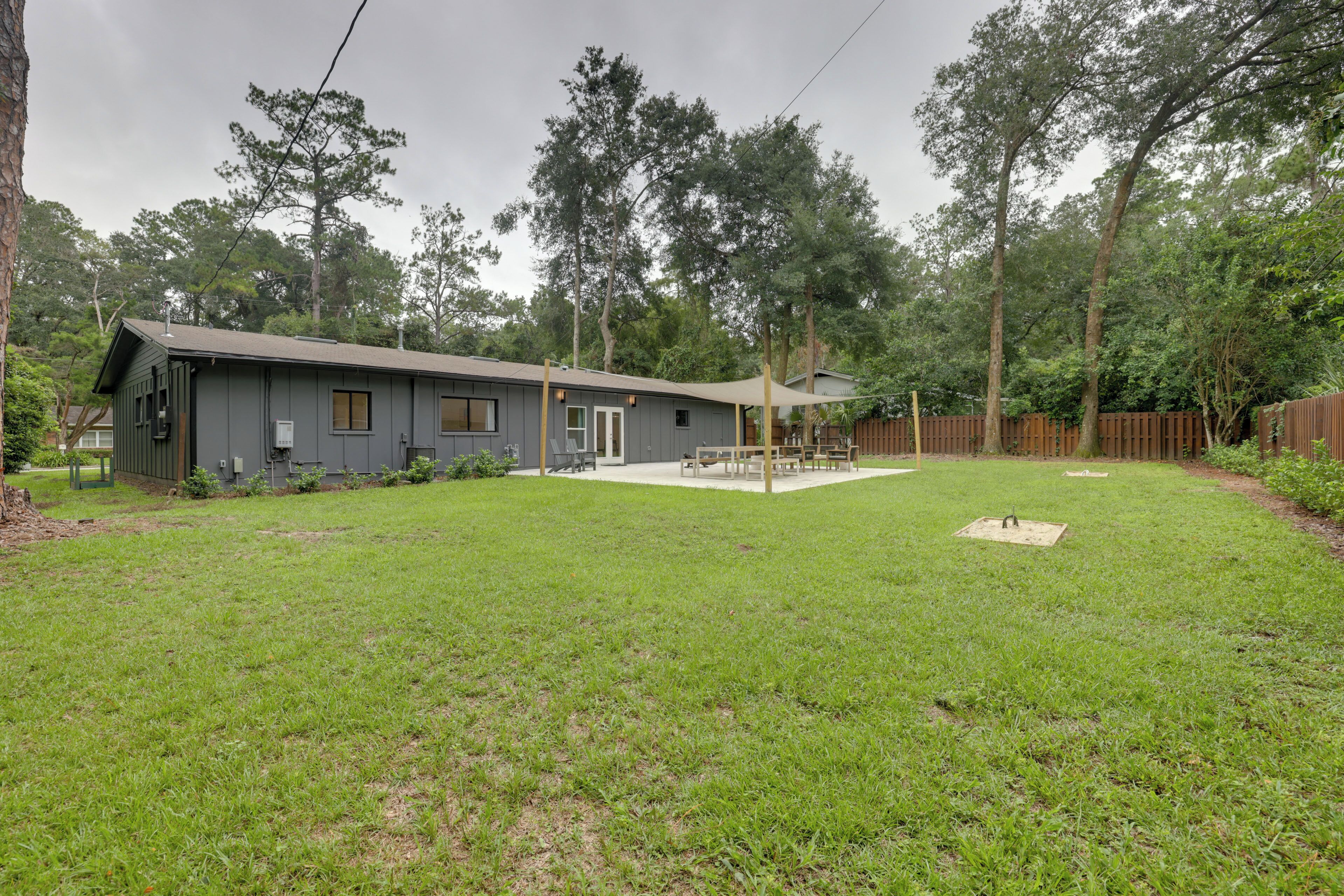 A two-story house with a covered patio and a fenced backyard.