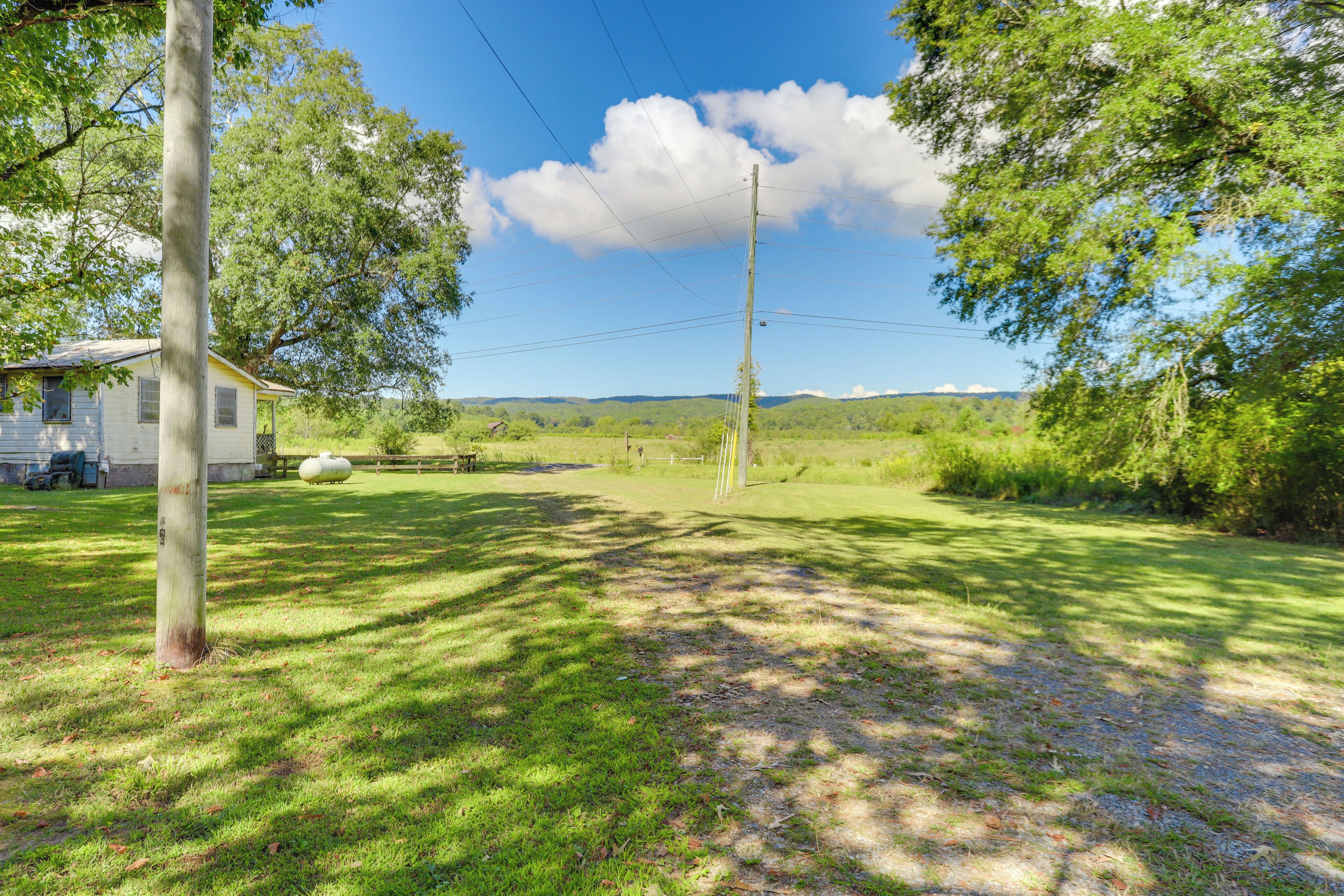 A rural property with a house, a large white spherical object, and a grassy area with trees.