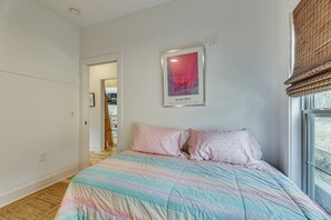 A bedroom with a bed, a window with blinds, a door leading to another room, and a framed picture on the wall. - Modern Home Near Lake Martin: Fishing Pond On-site (Eclectic)