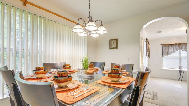 A dining area with a glass table, metal chairs, and a hanging light fixture. - Home w/ Dog-friendly Yard in Quiet Atlanta Suburb (Hampton)