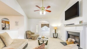 A living room with a sofa, armchair, coffee table, fireplace, television, and ceiling fan. - Home w/ Dog-friendly Yard in Quiet Atlanta Suburb (Hampton)