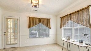 A room with a door, a window with curtains, a desk with a lamp, and a rug. - Home w/ Dog-friendly Yard in Quiet Atlanta Suburb (Hampton)