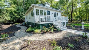 A house with a porch, a staircase, and a garden area.