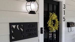 En sort dør med et skilt der viser "The Royal Swan" og nummeret "315" på væggen.