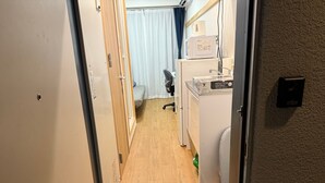 A narrow hallway with a wooden floor, a small desk with a computer, a microwave, and a kettle on top. - Y202 - Great Quiet Location Yoga (Setagaya City)